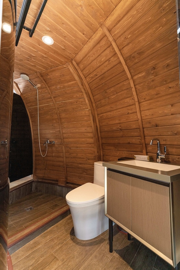 A wooden interior with a shower, toilet, and sink. - Imperial Mount Resort (Ulaanbaatar)