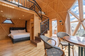 A wooden cabin interior with a bed, staircase, and a dining area. - Imperial Mount Resort (Ulaanbaatar)