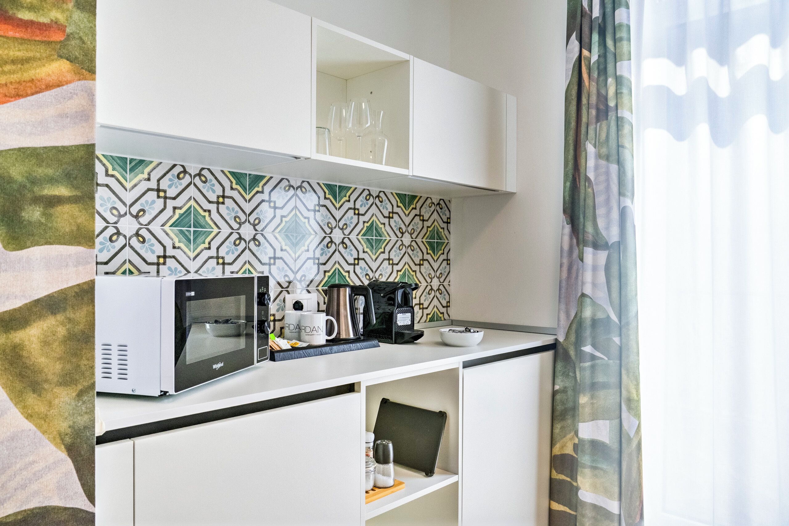 A kitchenette with a microwave, coffee maker, and a shelf with a mug and salt shaker.
