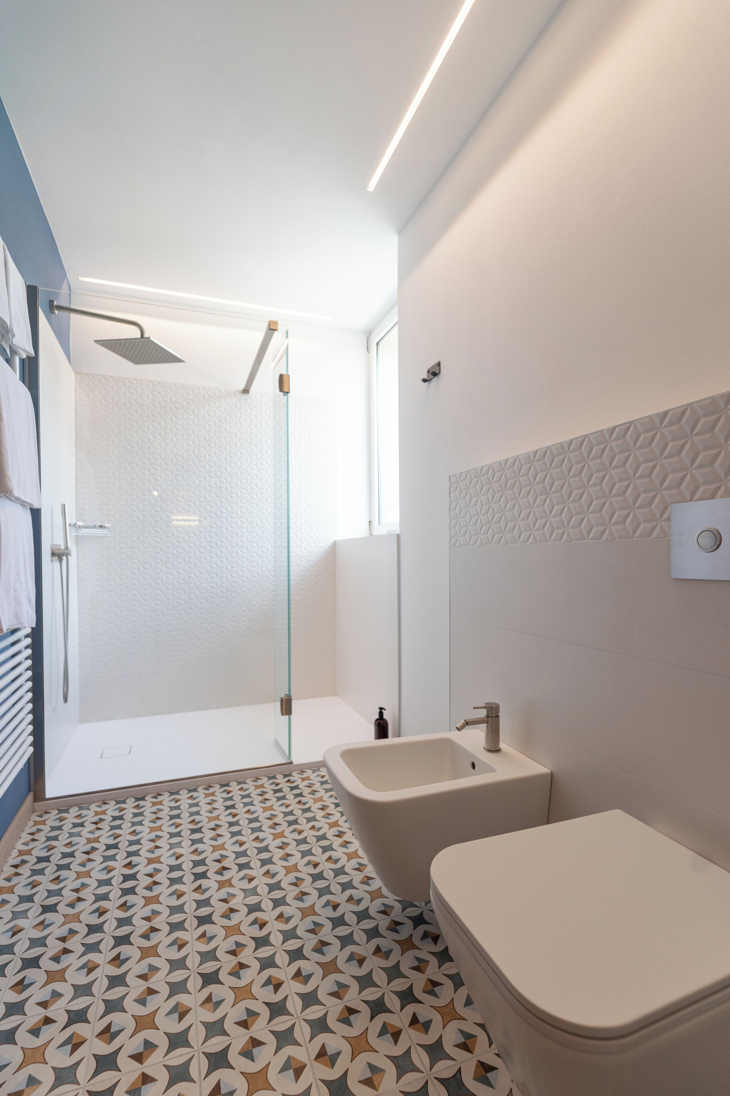 A modern bathroom with a shower, a sink, and a toilet.