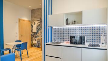 A compact kitchenette with a microwave, a coffee maker, and a small refrigerator.