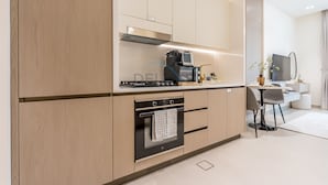 Eine moderne Küche mit Holzausstattung, einem eingebauten Backofen, einer Mikrowelle und einem Essbereich mit Tisch und Stühlen.