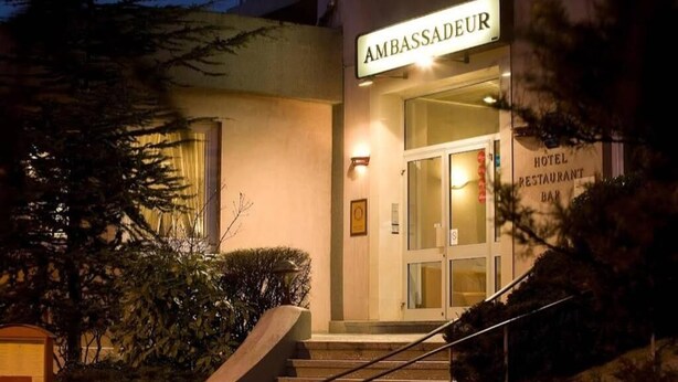 A hotel entrance with a sign reading "AMBASSADEUR" and a visible "HOTEL RESTAURANT BAR" sign. - Hôtel les nouveaux Ambassadeurs (Saint-Chamond)