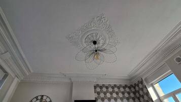 Ein Zimmer mit einer verzierten Decke, einer Uhr und einer Wand mit Muster.