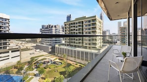 A balcony with a clear view of a cityscape, including modern buildings and a landscaped area with a pool. - 1BR with Huge Balcony Near Burj Al Arab (Dubai)