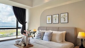 A hotel room with a large bed, a view of the outdoors, and three framed floral artworks on the wall. - R&F Princess Cove near CIQ by Stayrene (Johor Bahru)
