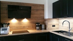 Eine moderne Küche mit integriertem Mikrowellenherd, Kaffeemaschine und einer Spüle aus Edelstahl.