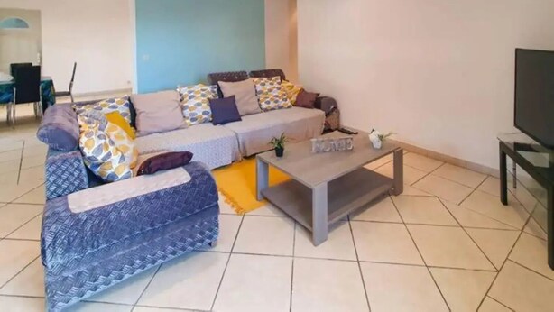 A modern living room with a sofa, coffee table, and a TV. - Ylang Chambres d'Hôtes, Your Villa in Petite Terre, Mayotte (Dzaoudzi Labattoir)
