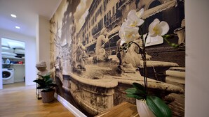 A room with a large mural of a fountain, a wooden bench, and potted plants. - Stylish Apartment for 4 near Metro B1 - Easy Access to Rome Center (Roma)