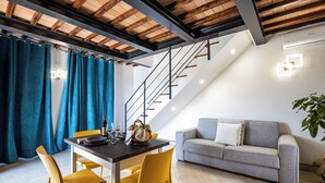 A dining area with a table, chairs, and a staircase leading to an upper level. - Giulia Suite with private hot tub (Rivalto Chianni)