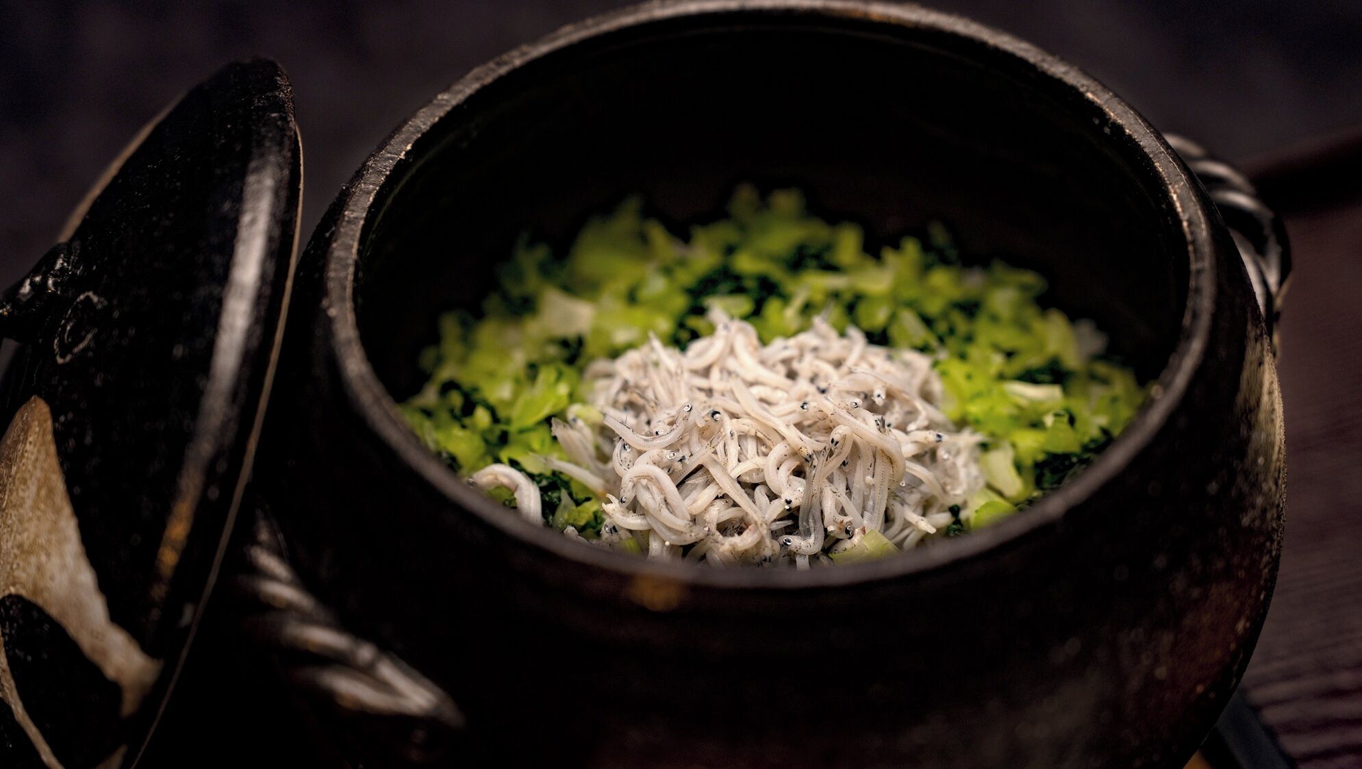 A bowl with noodles and greens, possibly a dish.