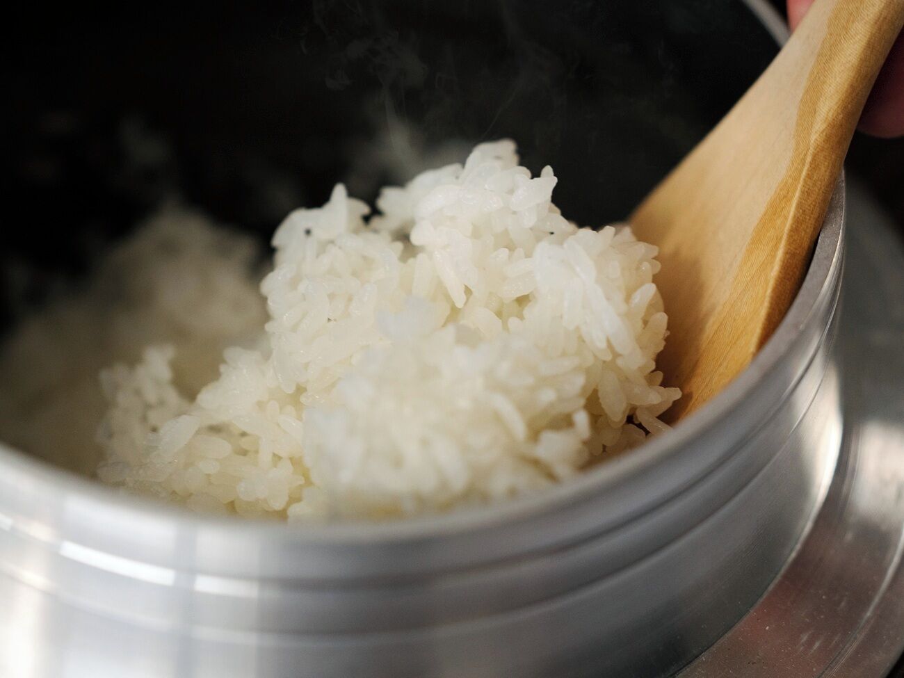 Un tazón de arroz blanco cocido con vapor saliendo.