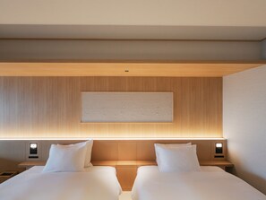 A hotel room with two beds, a wooden headboard, a wall-mounted artwork, and bedside lamps. - YOKI MATSUSHIMA (Matsushima)