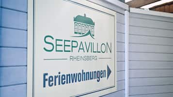 Un cartel para 'SEEPAVILLON' que indica 'Ferienwohnungen' (apartamentos vacacionales) en 'RHEINSBERG'.