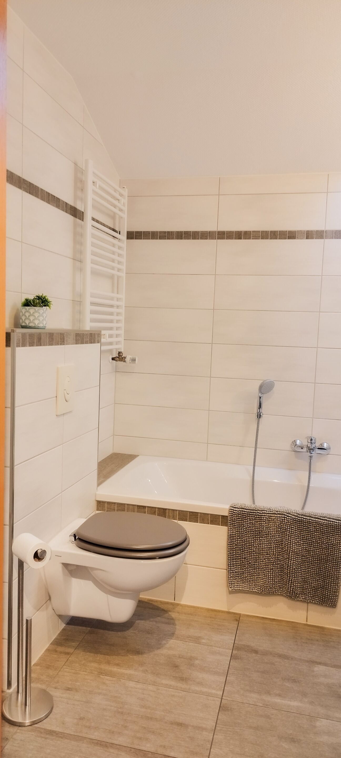 A bathroom with a toilet, a bathtub, and a shower.