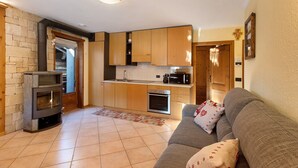 Ein gemütlicher Wohnraum mit Küche, Kamin und einer Couch.
