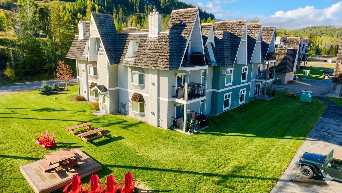 A multi-story building with a symmetrical facade, a well-maintained lawn, and a visible driveway.