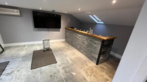 Uma cozinha moderna com painel de pedra, bancada de madeira e forno embutido.