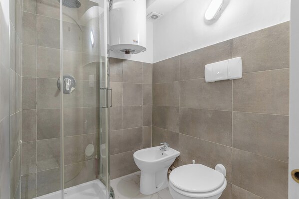 A bathroom with a shower, bidet, and toilet. - Welcome Foresteria Lombarda (Milan)