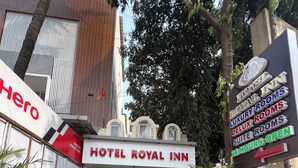 L’entrée de l’hôtel Royal Inn, avec une pancarte indiquant qu’il est ouvert 24 heures sur 24.