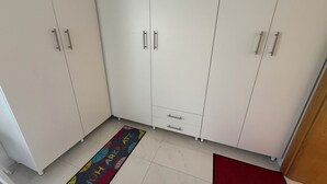 A room with white cabinets, a colorful rug with 'SOUTH PARK PLATZ' text, and a red mat at the entrance. - Apartments Vista Bliss 2 (Crikvenica)