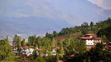 A mountainous landscape with residential buildings, including a prominent white building with a red roof.