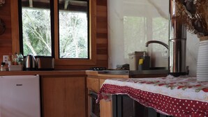 Une cuisine de taille réduite, dotée de meubles en bois, d’un réfrigérateur en acier inoxydable, d’une cuisinière et d’un évier.