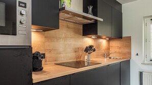 A modern kitchen with a built-in oven, a coffee maker, and a knife block. - Hofvilla Winterswijk for 6 guests with 3 bedrooms and 2 bathrooms. Large garden, high comfort and pets welcome. (Kotten)