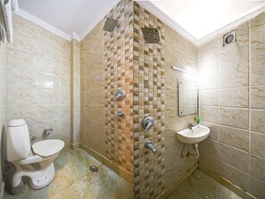 A bathroom with a toilet, a shower with a tiled wall, and a sink. - HOTEL REPOSE VILLA  (New Delhi)