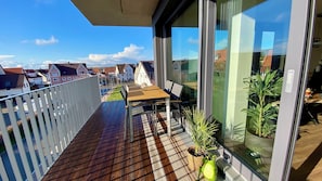 A balcony with a wooden floor, a table, chairs, and potted plants. - Relaxation at the foot of the Swabian Alb | Cozy apartment in Weilheim / Teck (Weilheim an der Teck)