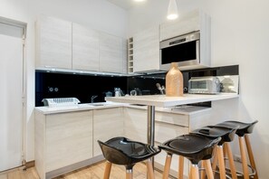 Une cuisine moderne dotée d’un îlot central, de tabourets de bar, d’un four à micro-ondes et d’un four encastré.