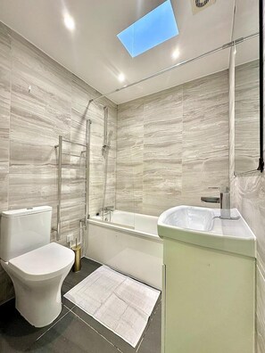 Combined shower/bathtub, deep-soaking bathtub, hair dryer, towels - Top-floor Apartment by the Station (London)
