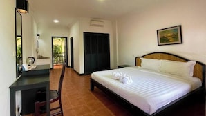 Une chambre d’hôtel comprenant un lit, un bureau avec une chaise, un tableau au mur et un appareil de climatisation.