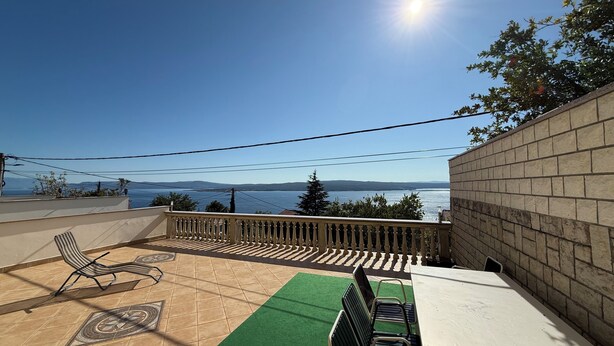 A terrace with a view of the sea, a table, chairs, and a patterned floor. - Apartments Vista Bliss 3 (Crikvenica)