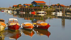 Un puerto deportivo con barcos amarrados, edificios de madera y cielo despejado.