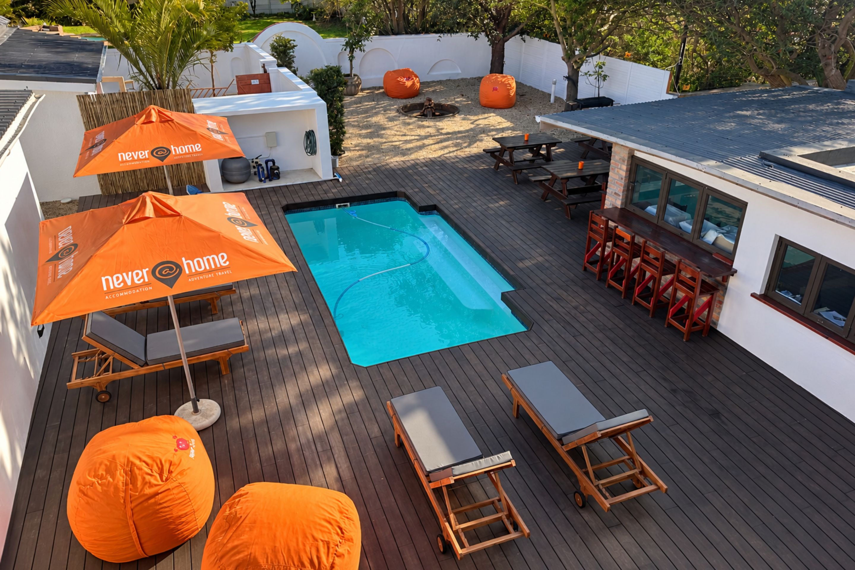 A rooftop pool area with a pool, lounge chairs, and a bar area.