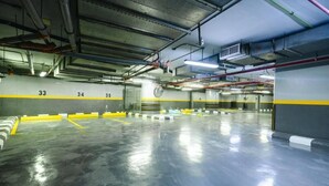 Eine mehrgeschossige Parkgarage mit deutlich markierten Stellplätzen und einem sauberen, spiegelnden Boden.