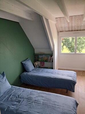 A room with two beds, a green wall, a window with a view of trees, and a shelf with books and a 'dream' sign. - Villa Coat Ar Mor, 700m from the beach (TREVOU-TREGUIGNEC)