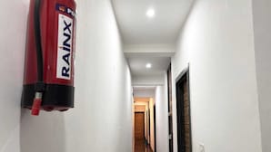 A hallway with a fire extinguisher mounted on the wall. - Devi Heritage (Mathura)