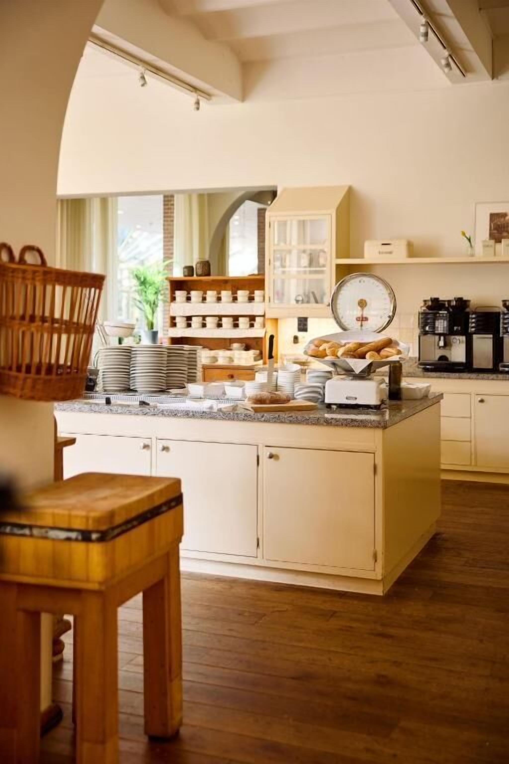 A kitchen with a central island, wooden cabinets, and a coffee machine.