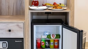 Una kitchenette compacta con refrigerador, cafetera y microondas.