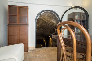 Uma área de refeições com uma mesa e cadeiras de madeira, um armário e uma estante.