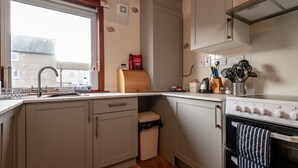 Una cocina con pileta, estufa y alacenas.