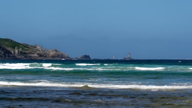 A coastal view with waves, a lighthouse, and rocky cliffs. - Seaside Escape in Audierne: Maritime-Themed Cottage at the Tip of Southern Finistère (Audierne)