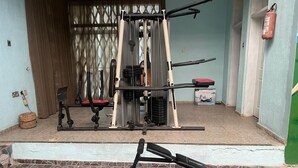 A home gym with a pull-up bar, a bench, and a weight bench. - Room-flexible 8-bedroom Luxury Apartment (Benin City)