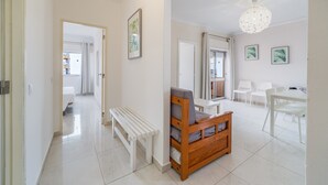 Ein modernes Interieur mit einer Holzbank, einem Esstisch mit Stühlen und einer Deckenleuchte.