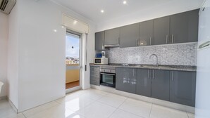 Eine moderne Küche mit grauen Schränken, einer gefliesten Spritzschutzwand und einem eingebauten Backofen.