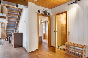 A staircase with patterned rugs, a wooden bench, and a hallway leading to a door. - Apartment with Mountain View Steinbühl 4 with Private Terrace and Balcony (Wieden)
