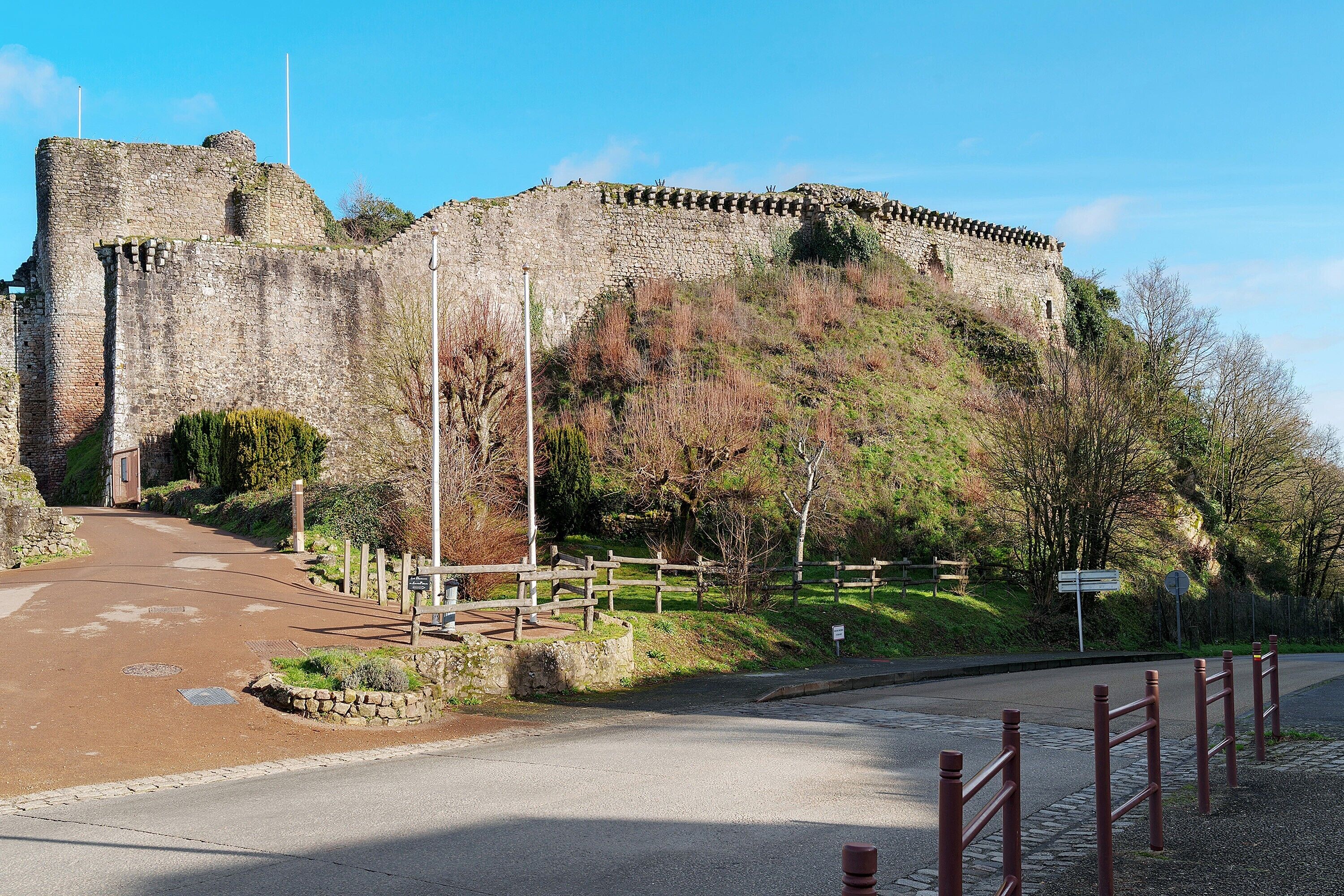 Um castelo de pedra histórico com um caminho pavimentado que leva à sua entrada.