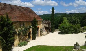 A rustic stone building with a tiled roof, surrounded by greenery and a gravel driveway. - Les Hauts de Valojoulx - Guest Room “La Lézardière” with Private Terrace, Wi-Fi, AC (Valojoulx)